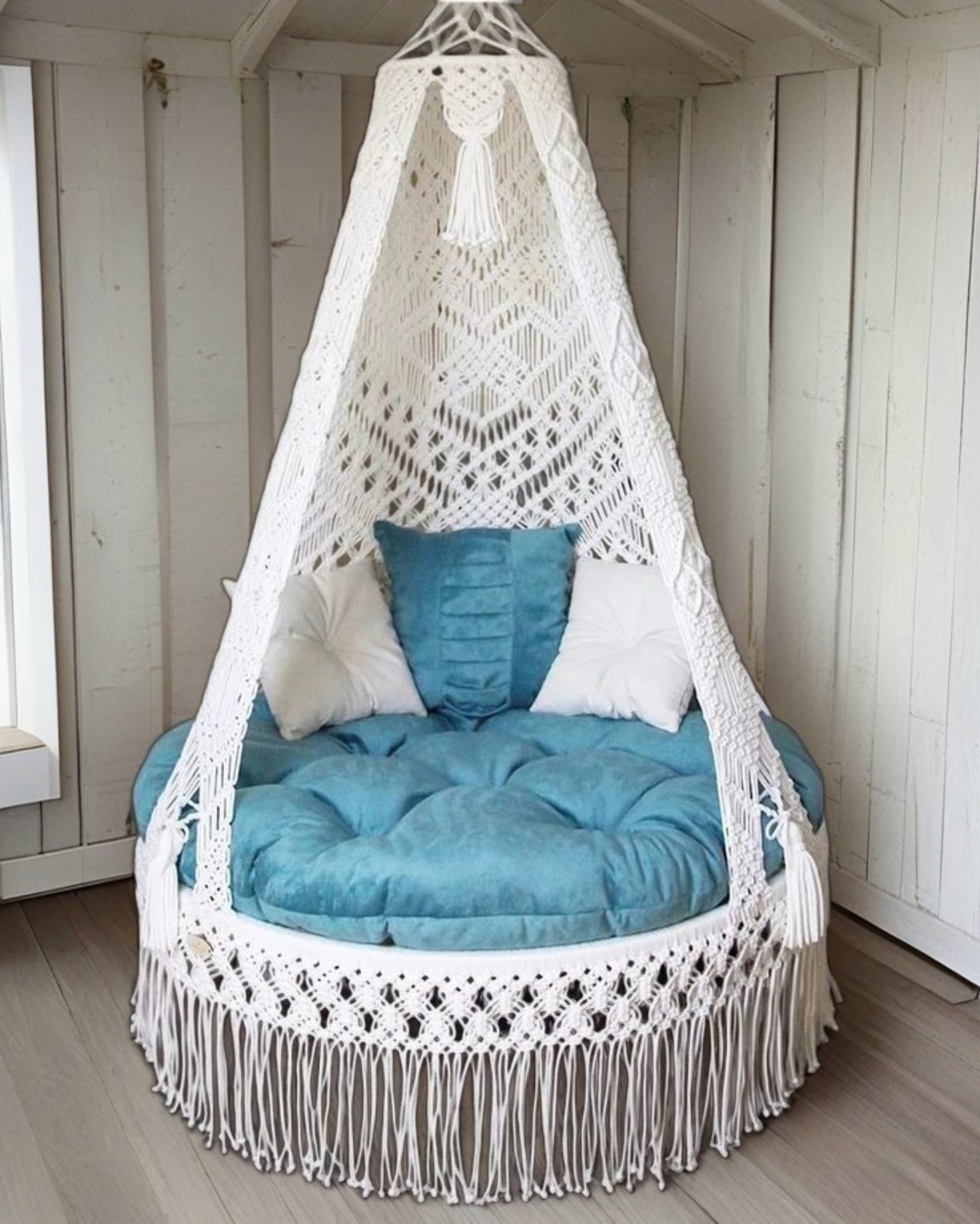 White macrame swing with blue mattress for home