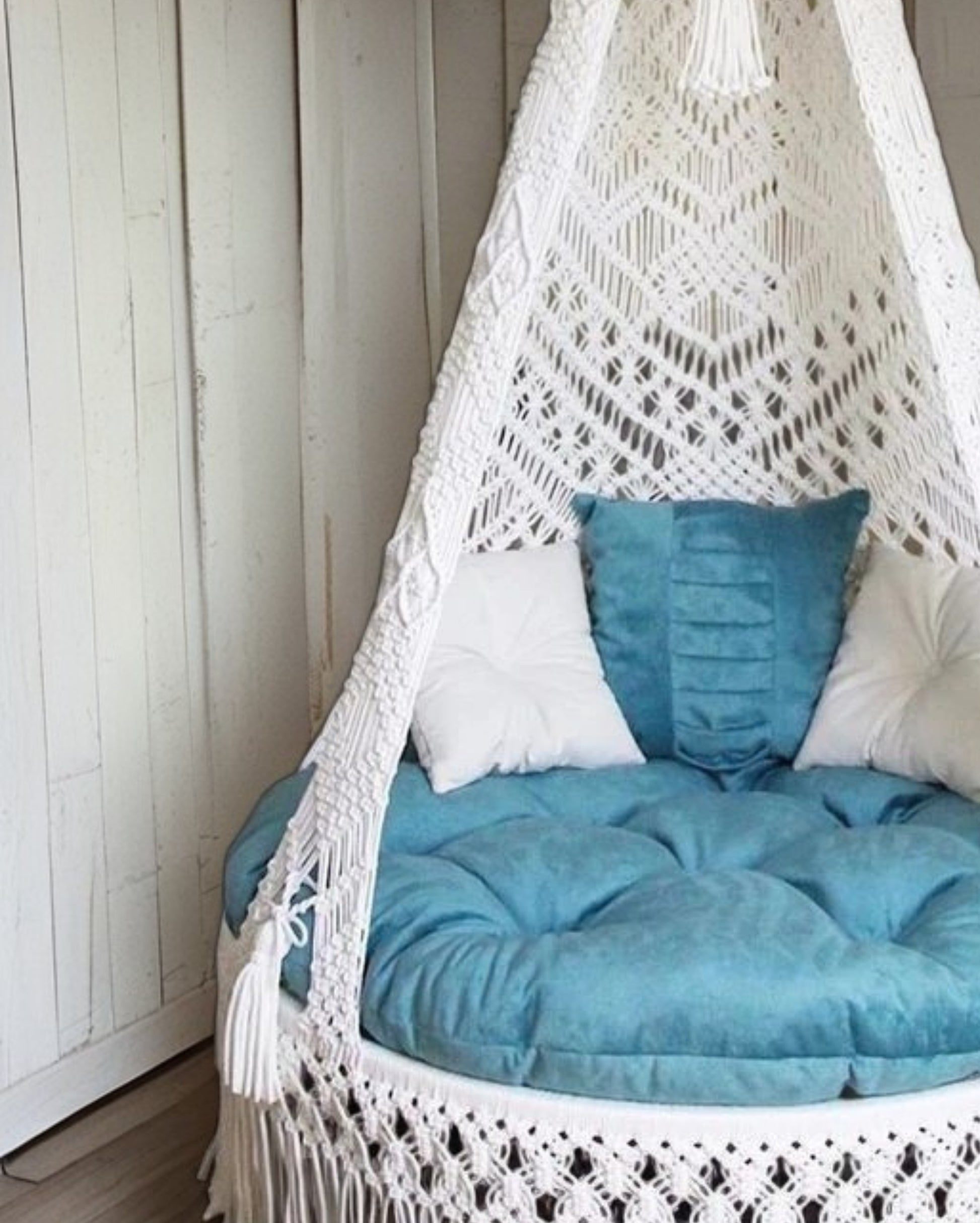 White macrame swing with blue mattress for home